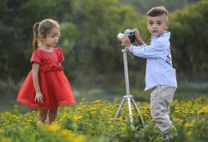 young children playing a photographer and model taking pictures for a fashion shoot